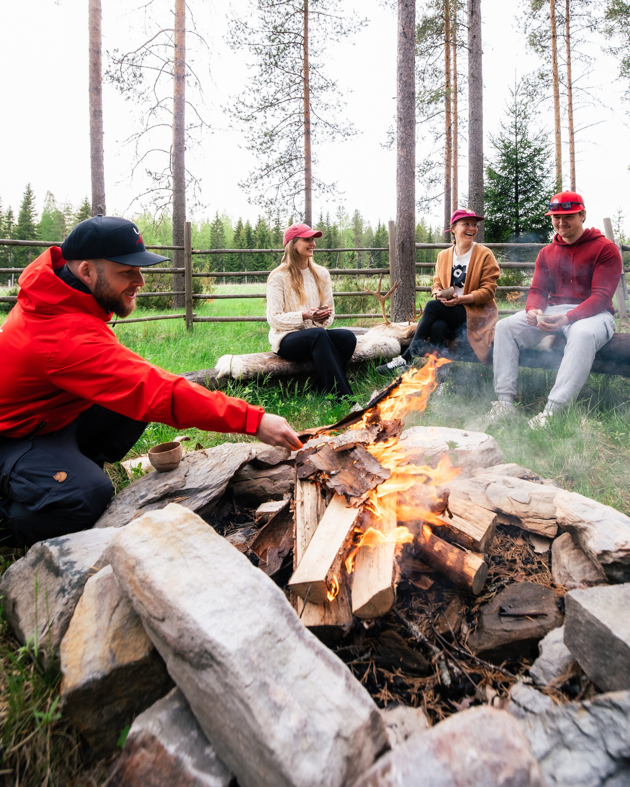 Travellers enjoying Live the life of a reindeer herder by Santa Claus Reindeer in Rovaniemi, Lapland, Finland People are having fun outdoors at the campfire