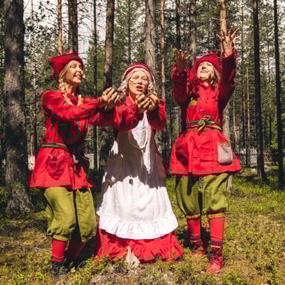 Mrs Santa Claus and her elf are playing in the summer at the forest