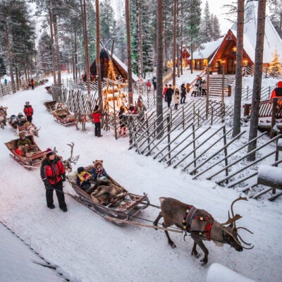 Reindeer sleighs depart at Santa Claus Reindeer in Santa Claus Village, Rovaniemi, Finland Mrs Santa Claus and her elf is baking gingerbread cookings for Christmas
